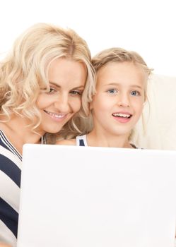 bright picture of happy mother and child with laptop computer (focus on woman)