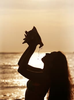 Silhouette of the beautiful girl with a cockleshell