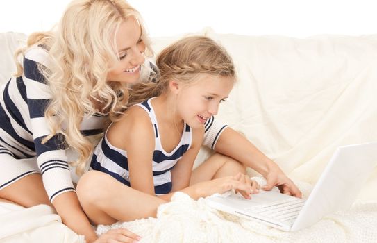 bright picture of happy mother and child with laptop computer (focus on girl)