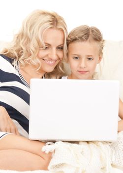 bright picture of happy mother and child with laptop computer