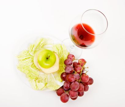 green apple in a glass of wine and grapes