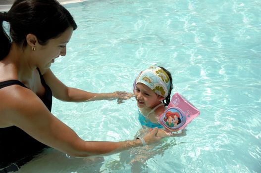 Happy woman and child is relaxing in pool