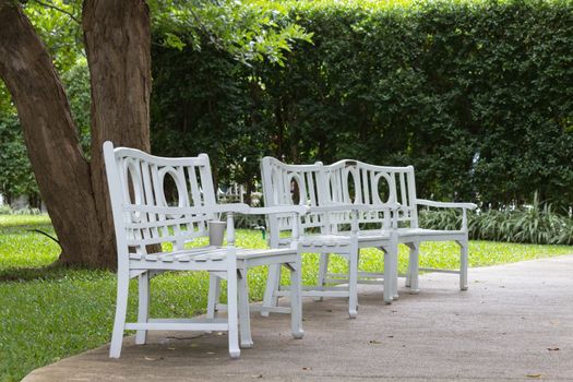 Three white chairs on the pathway.