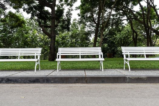 Three white chairs in the garden.