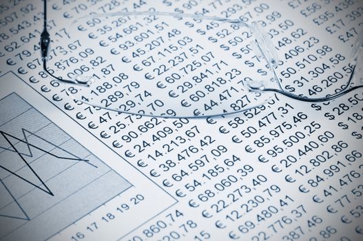 Eyeglasses on top of a sheet of paper white a chart and numbers