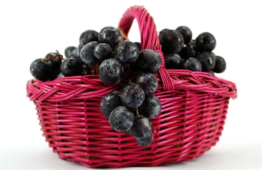 Basket with grapes on white background