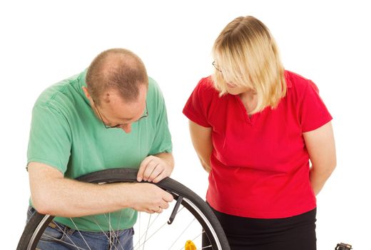 A mechanic repairs the wheel of a bicycle
