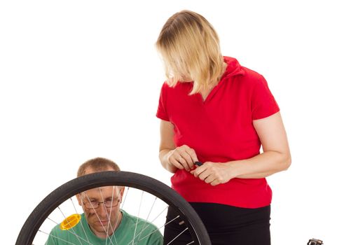 A mechanic repairs the wheel of a bicycle