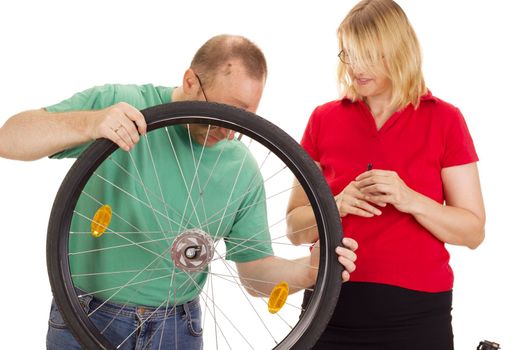 A mechanic repairs the wheel of a bicycle