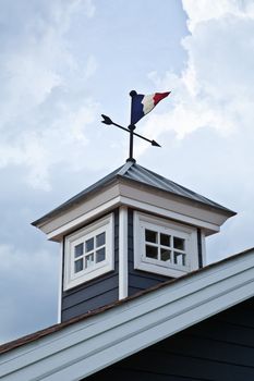 Wind arrow direction on blue cloudy sky