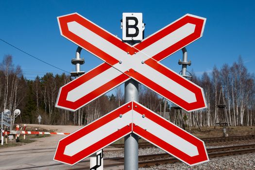 red-white railway sign against a blue sky.