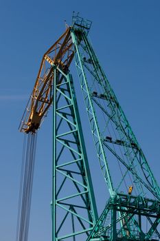 Big green crane in sunny day at blue sky
