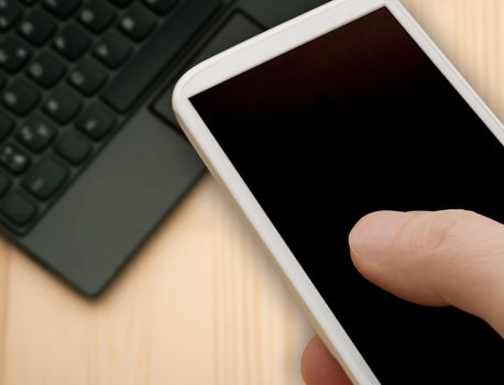 Closeup of Man's Hand Touching Screen of Smartphone in Office