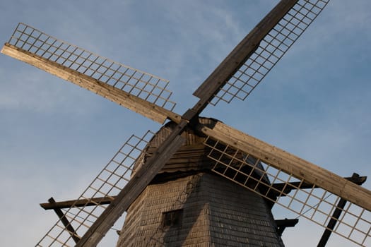 Old wooden windmill wings against blue sky