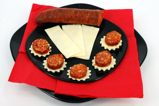 Sausage and cheese on black dish