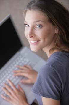 Portrait of a smiling woman using her laptop at home