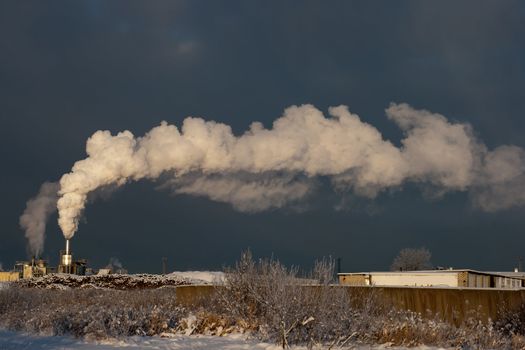 Factory smoke in the dark winter sky