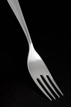 Elegant silver fork from 70s, on dark background.