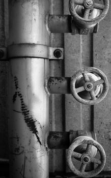 Old rusty pipe and valves concret background