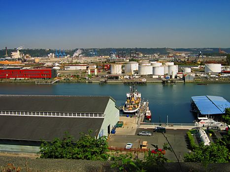 A photograph of an urban manufacturing and commerce area located near a waterway.