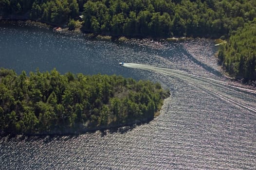 Small boat tracks on surface of water in sunlit