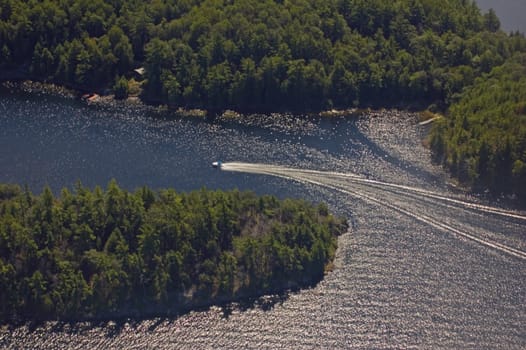 Small boat tracks on surface of water in sunlit