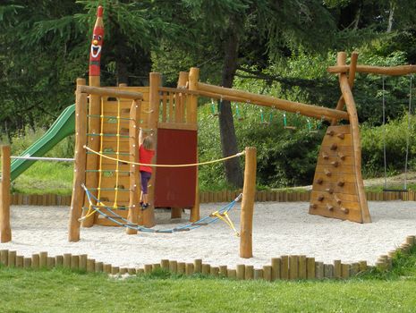 Photo of a child what playing on a playground alone.