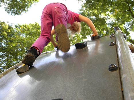 Photo of a child, which climbs on a playground.