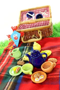 Picnic basket and dishes on a picnic blanket