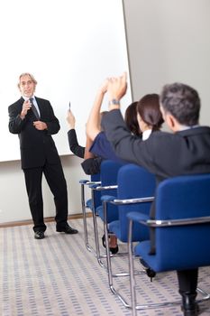Portrait of a confident senior manager giving presentation to his colleagues at office