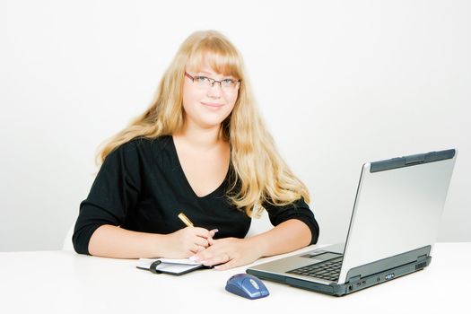 smiling blond girl with a laptop and notebook