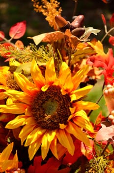 A yellow sunflower is the central piece of this fall arrangement