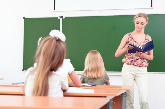 teacher stands in front of students in the class