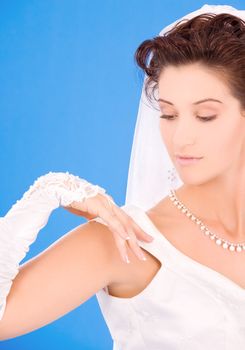 happy bride with her wedding ring over blue