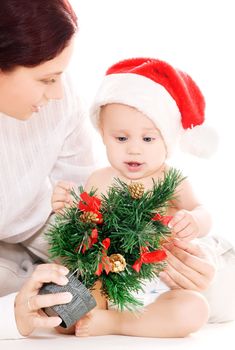 baby and mother with christmas gifts over white