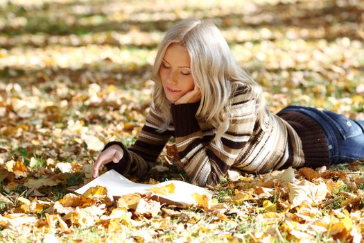 woman read the book in autumn park