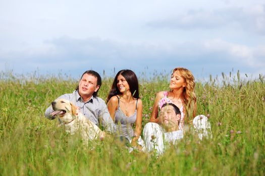 friends and dog in green grass field