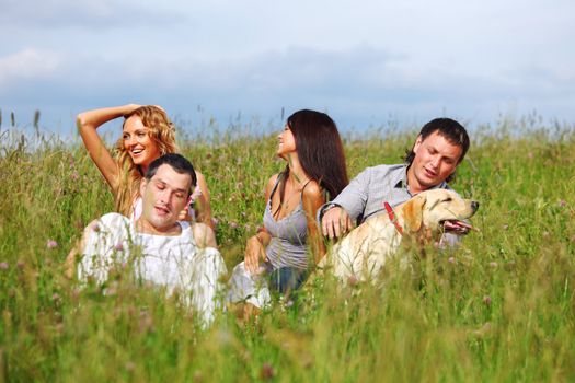 friends and dog in green grass field