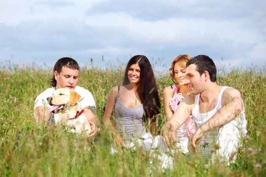 friends and dog in green grass field