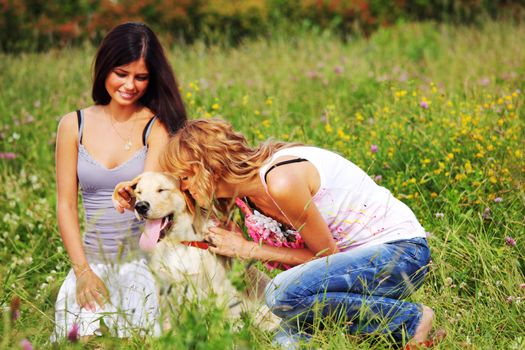 girlfriends and dog in green grass field