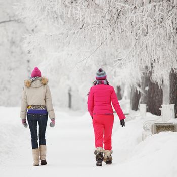 two winter women run by snow frosted alley