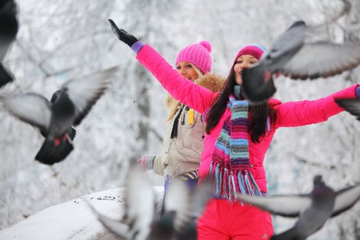 winter women give food to the pigeon