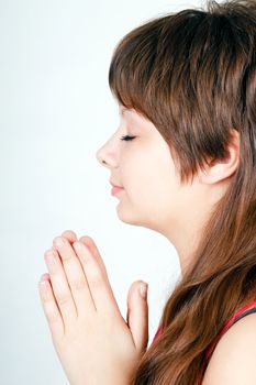 ger girl folded her hands in prayer. Profile view