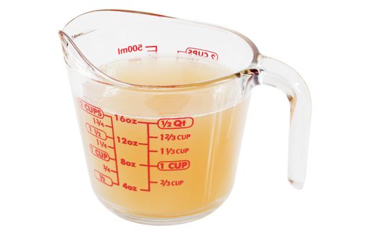 Chicken stock in glass measuring jug.