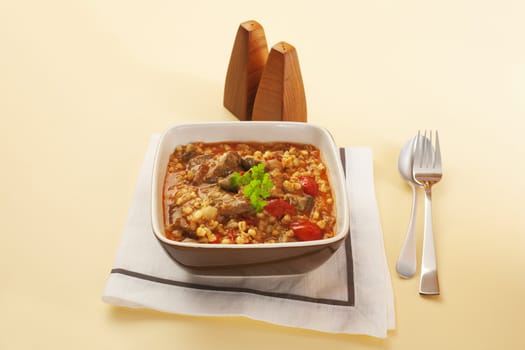 A bowl of homely lamb stew with barley, mushrooms and tomatoes.