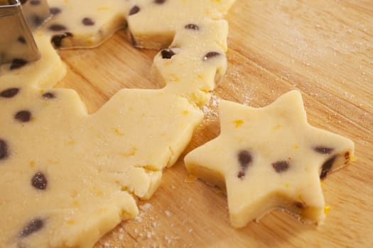Chocolate chip cookie dough, with a star shape cut out. Also contains grated orange rind. Shallow DOF, focus on centre.