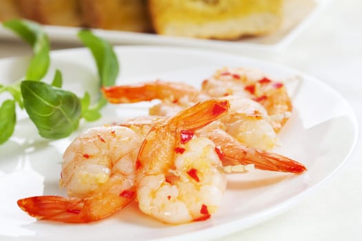 Prawns on skewers in garlic and chilli, with garlic bread.