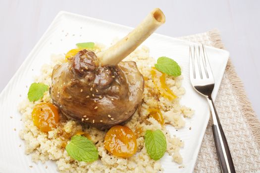 Moroccan tagine, lamb shank cooked with ginger, cinnamon, honey and apricots, served over couscous.