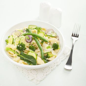 Conchiglie or pasta shells with alfredo sauce and spring vegetables - broccoli, green beans, courgette or zucchini, mushrooms and onions - make pasta primavera a delicious vegetarian meal.