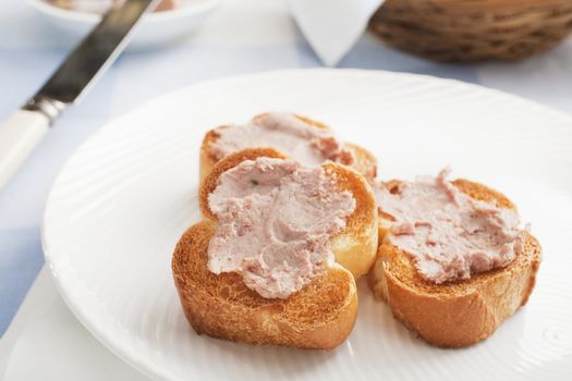 Three pieces of toasted baguette spread with Ardennes pate.